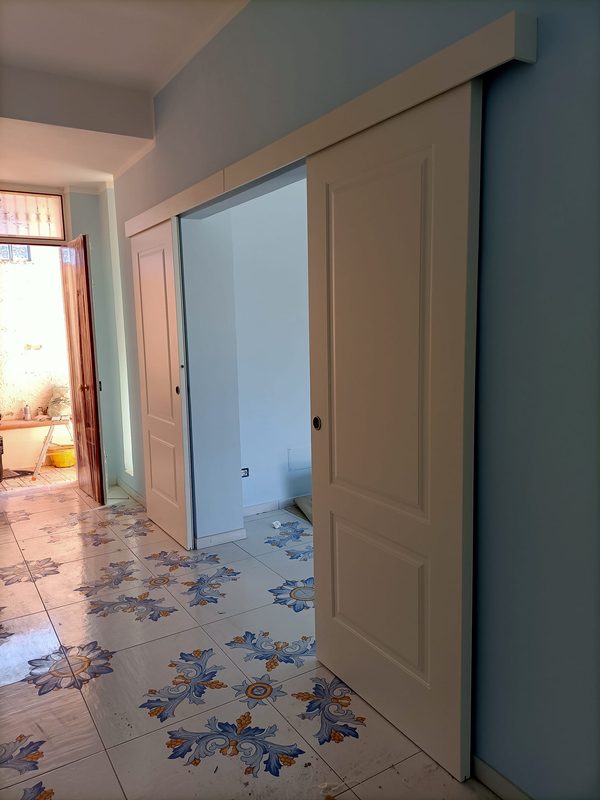 Porta scorrevole classica bianca esterno muro pavimento maiolica